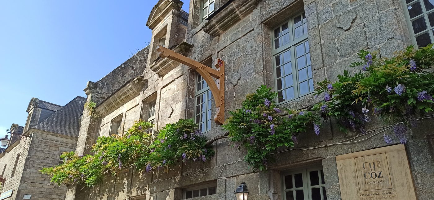 Console en chêne installée sur la façade en pierre d'un restaurant à Locronan