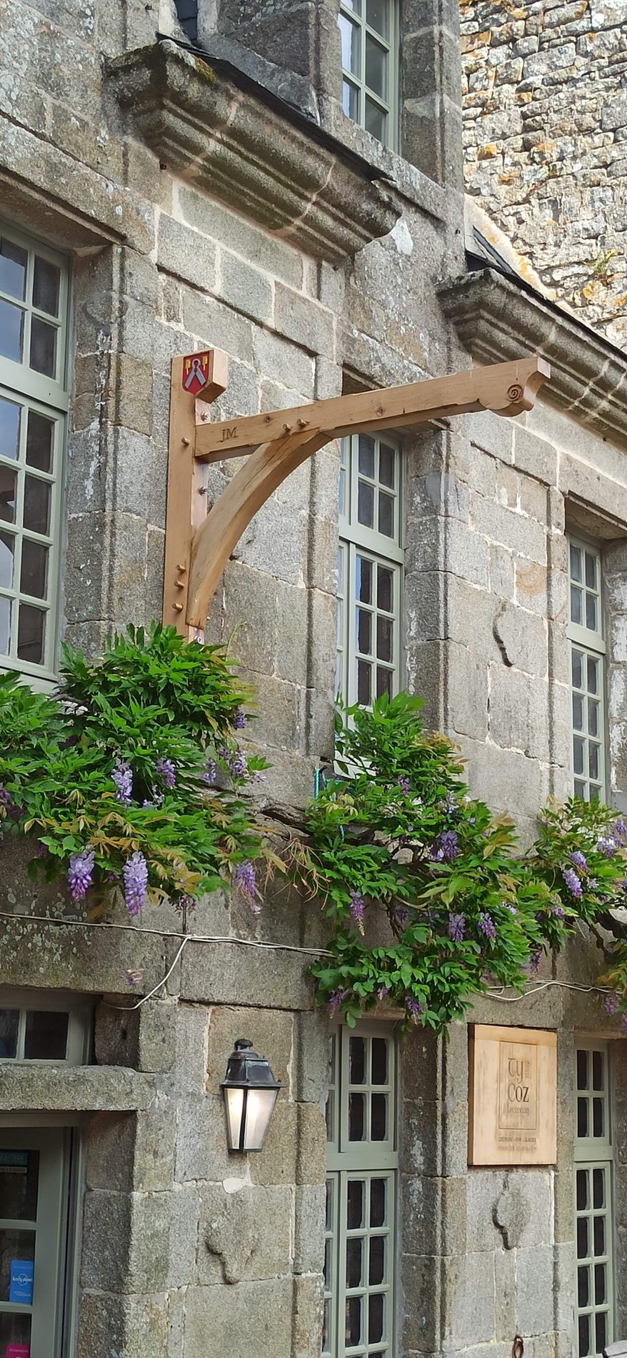 Console en chêne posée sur la façade, sous la glycine en fleurs