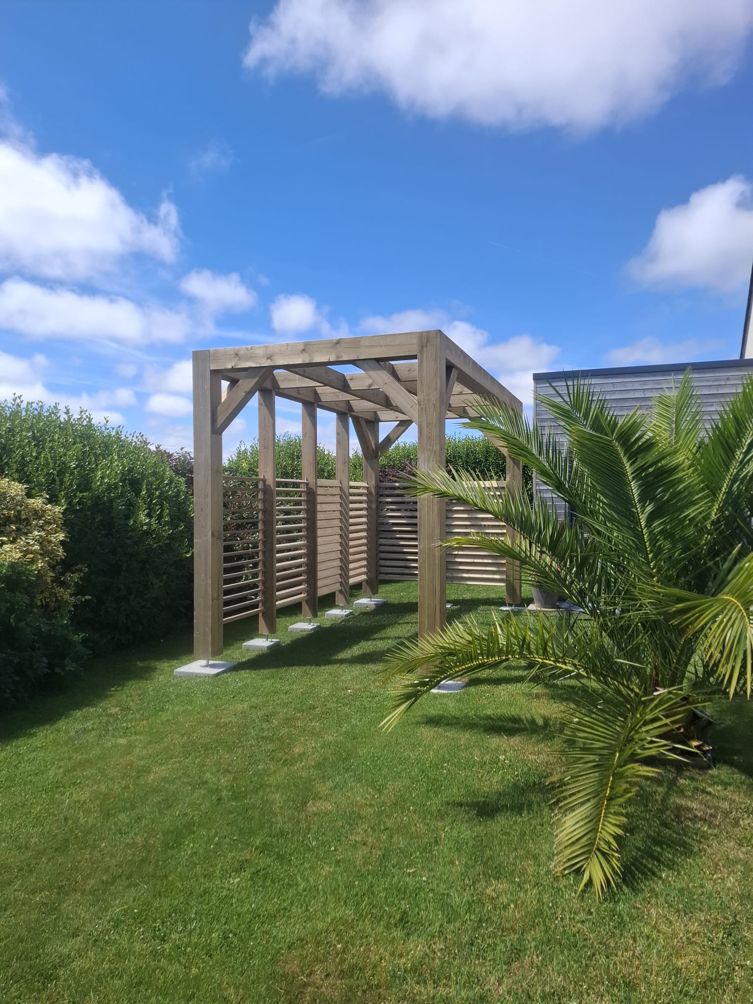 Vue latérale de la pergola en pin traité à lames orientables