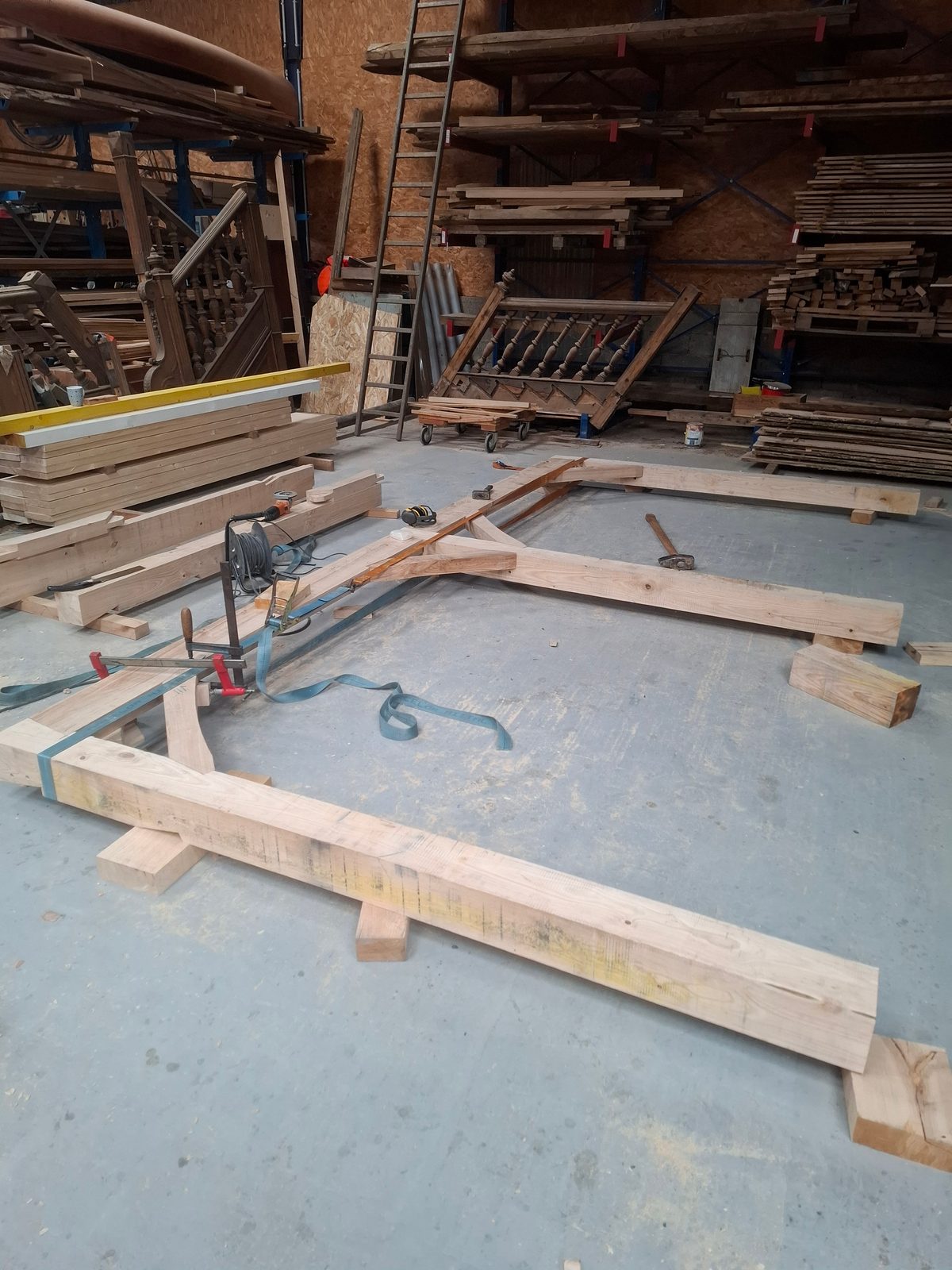 Pergola assemblée à plat en atelier : mise sur ligne et chevillage à la tire des tenons-mortaises