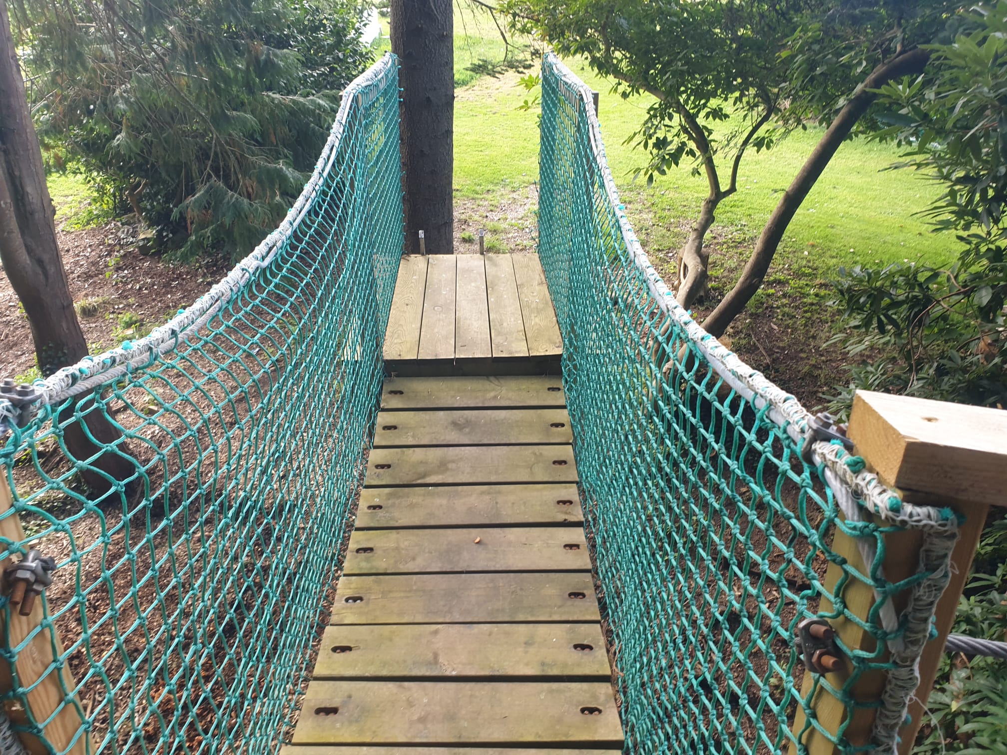 Pont de singe en bois et filet menant à la plateforme perchée